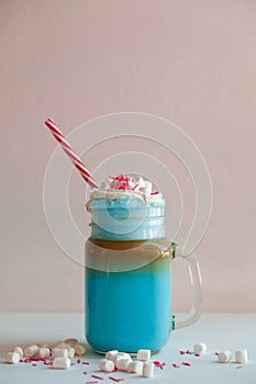 Blue coffee with cream, marshmallow and colorful decoration. Milk shake.