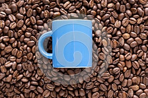 Blue coffee cup on coffee beans
