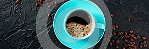 Blue coffee cup and coffee beans panorama, overhead flat lay shot on black