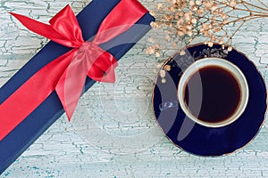 Blue coffee cup and gift box on wooden table, rustic style