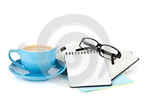 Blue coffee cup, glasses and office supplies