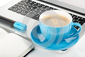 Blue coffee cup, laptop and office supplies