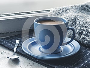 Blue coffee cup on the windowsill