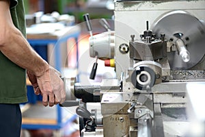 Blue-collar worker doing manual labor with a lathe