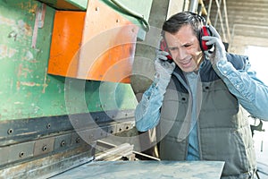 blue collar worker at noisy workplace