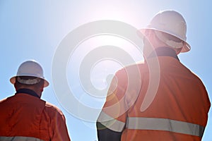 Blue collar workers isloate dagaint blue sky with sun flare photo