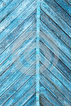 Blue color old wooden diagonal symmetrical planks with peeled paint background