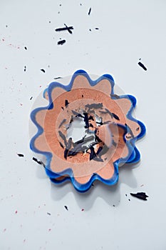 Blue color pencil shavings in a flower shape on a white background
