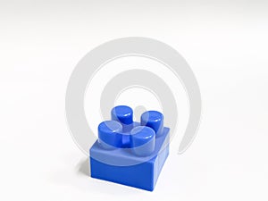 Blue color plastic building block against white background. Education and development concept.