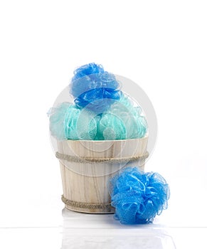 Blue color sponges into a wood basket against bathroom ambiance