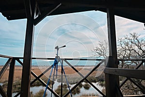 Blue color tripod for photographers standing inside bird watching tower