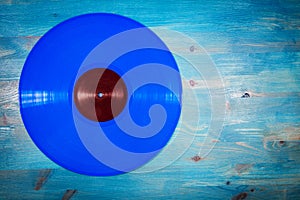 Blue color vinyl record on blue wooden background