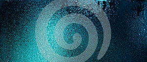 Blue color water drops on wet glass. Abstract texture background