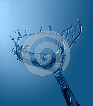 Blue color water splash isolated on empty background, studio photo
