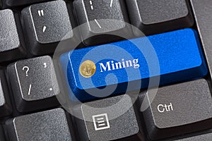 Blue colored Bitcoin Mining button on black computer keyboard. Crypto currency Internet data privacy information security concept.