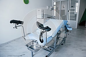 Blue colored obstetric bed indoors in the clinic cabinet at daytime