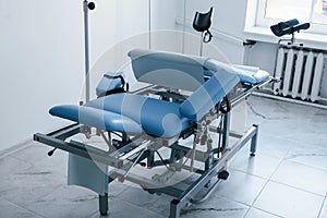 Blue colored obstetric bed indoors in the clinic cabinet at daytime photo