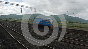 A blue colored railway locomotive running on tracks in Konkan