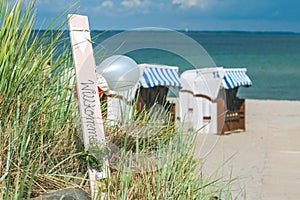 Blue colored roofed chairs on sandy beach in Travemunde, Welcome balloons. Germany