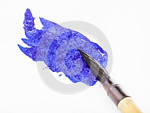 Blue colored tip of paintbrush in blot close up