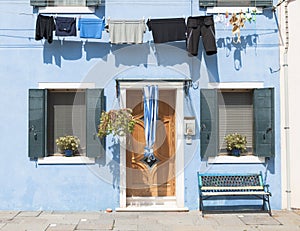 Blue colorful house of Burano Island with laundry, Venice, Italy