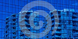 Blue coloured building reflecting off of blue glass photo