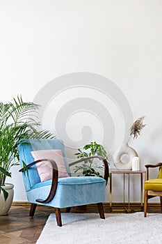 Blue comfortable armchair in apartment with vintage style interior