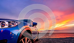 Blue compact SUV car with sport and modern design parked by beach at sunset. Hybrid and electric car technology. Car parking space