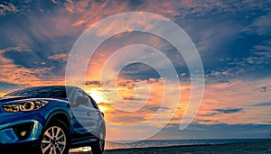 Blue compact SUV car with sport and modern design parked by beach at sunset. Hybrid and electric car technology. Car parking space