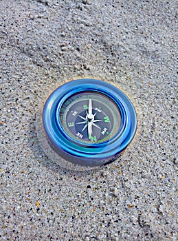 Blue compass on the sand