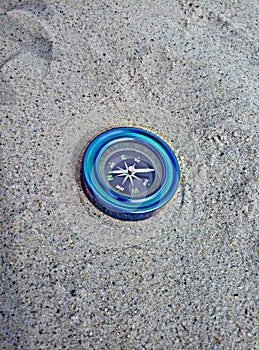 Blue compass on the sand