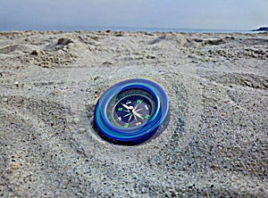 Blue compass on the sand