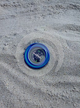 Blue compass on the sand