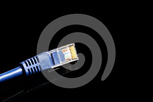 Blue computer ethernet cable isolated on black background, close-up