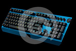 Blue computer keyboard with rgb colors isolated on black background.