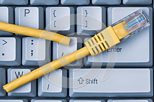 Blue computer keyboard with yellow network cable cutted off