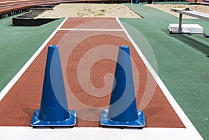 Blue cones blocking long jump pit indoors