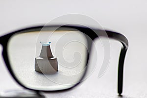 Blue contact lens through black eyeglasses shows different eyewear to correct farsightedness and nearsightedness by optometry