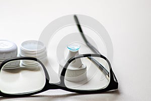 Blue contact lens through black eyeglasses shows different eyewear to correct farsightedness and nearsightedness by optometry