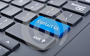 Blue contact us button on black keyboard concept