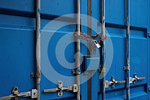Blue Container Door with Rusty Chain and Locked Padlock