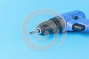 Blue cordless screwdriver on a blue background