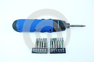 Blue cordless screwdriver or electric drill and replaceable bits isolated on white