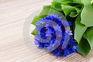 Blue corn flowers on wooden table