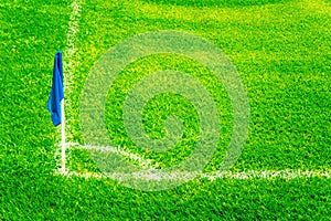 Blue Corner Flag on a Football Field with Bright Fresh Green Turf Grass and White Soccer Touch Lines