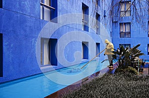 Blue courtyard - maintenance man in yellow slicker photo
