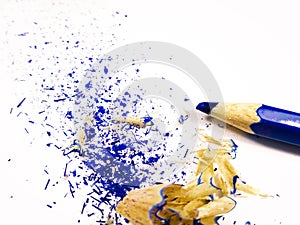 Blue crayon pencil with shavings on white background.