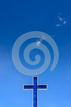 Blue cross on clear blue sky.