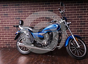 Blue Cruiser Motorcycle in front of Brick Wall