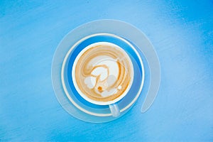 Blue cup of aromatic coffee on a blue table.
